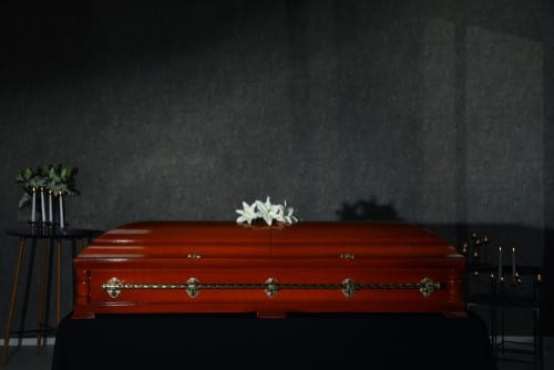 Coffin with white flower on top